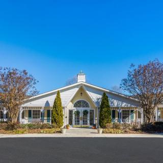 A symmetrical building with a clear blue sky and trees on either side.