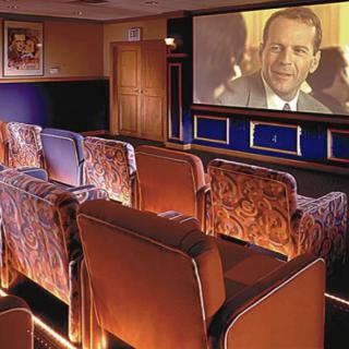 A cozy home theater room with comfortable seating and a large screen.