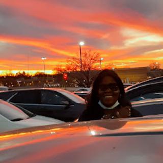 A beautiful sunset casts a vibrant glow over the parking lot, illuminating the scene.