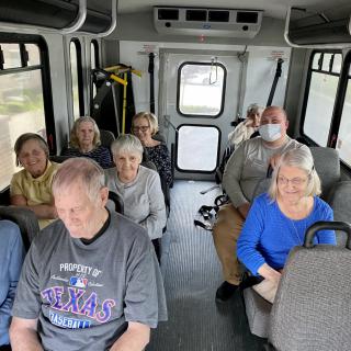 A group of people seated inside a bus, engaged in travel.