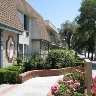A well-maintained apartment building with landscaped gardens and vibrant flowers.