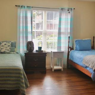 A cozy bedroom with twin beds, accented by blue and green decor.