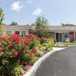 A charming residential home surrounded by vibrant flowers and greenery.