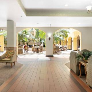 Spacious hotel lobby with elegant furniture and lush greenery.