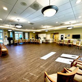 A spacious meeting room with arranged chairs and bright lighting.