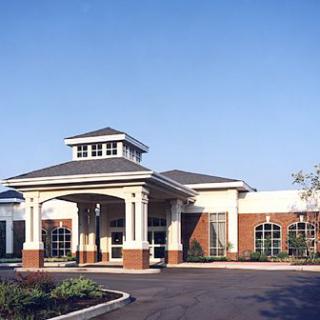 A modern healthcare facility with a prominent entrance and landscaped surroundings.