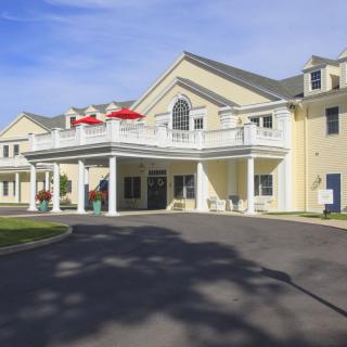 A large residential building with a prominent entrance and balcony during the daytime.