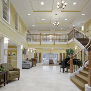 A spacious and elegant lobby with a grand staircase and comfortable seating area.