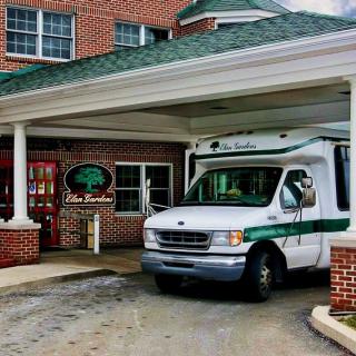 A transport van parked under the covered entrance of a building.