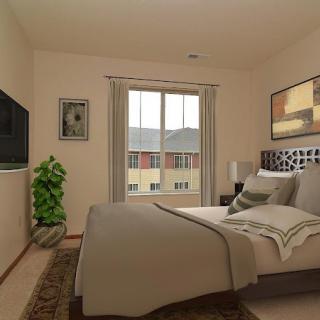 A cozy bedroom with a large bed, wall-mounted television, and decorative elements.