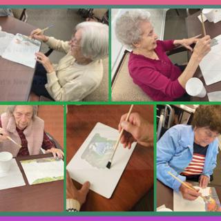 Seniors enjoying a painting activity in a community setting.