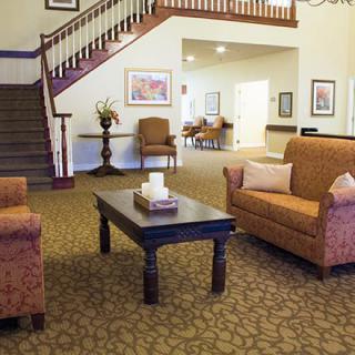 A cozy living room with comfortable seating and a decorative staircase.