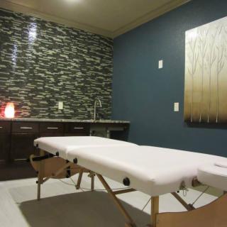 A tranquil massage room with a therapy table and soothing decor.
