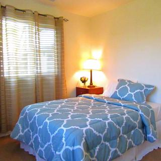 Cozy bedroom with a patterned blue bedspread and soft lighting.