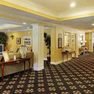 A well-lit hotel lobby with comfortable seating and decorative carpeting.
