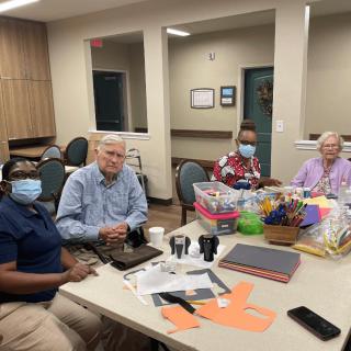 A group of adults sitting around a table having a meeting.