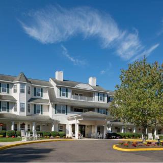 A charming hotel with a classic architectural style under a clear blue sky.