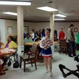 A cheerleader visiting a nursing home during a community event.