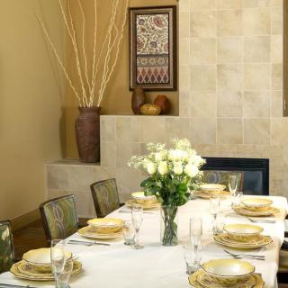 An elegantly set dining table with white roses and neatly arranged plates and glasses.
