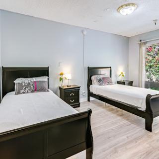 A bright and modern bedroom featuring twin beds with a minimalist design.