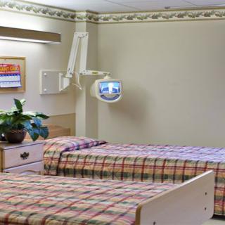 A hospital room with two beds and medical equipment.