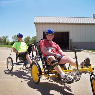 Two individuals enjoying a day of adaptive cycling on recumbent bikes.