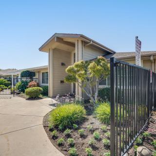 A well-maintained building with a landscaped garden and a black fence along the pathway.