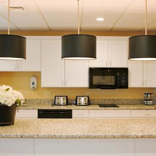 A modern kitchen featuring pendant lights and granite countertops.