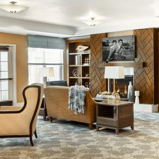 A cozy and well-decorated living room with comfortable seating, a television, and a bookshelf.