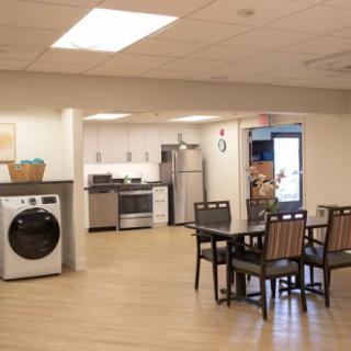 A modern open-plan kitchen and dining area with appliances and seating.