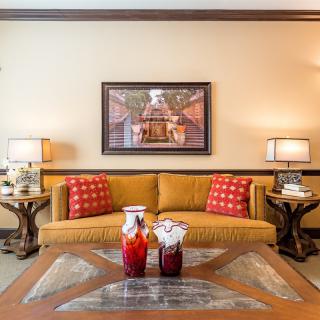 A cozy living room with a yellow sofa, red cushions, and elegant decor.