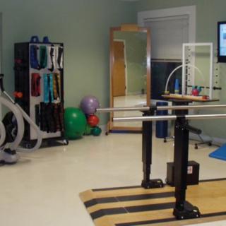 A physical therapy room equipped with exercise equipment and balance bars.
