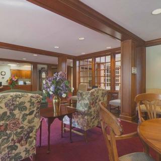 A cozy lobby area featuring floral upholstered chairs and rich wood paneling.
