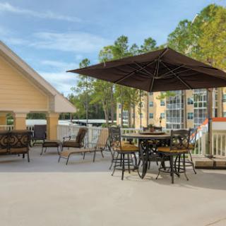 A serene outdoor patio area featuring comfortable seating and shaded spaces, perfect for relaxation amidst nature.