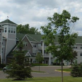 A multi-story building surrounded by trees in a scenic landscape.