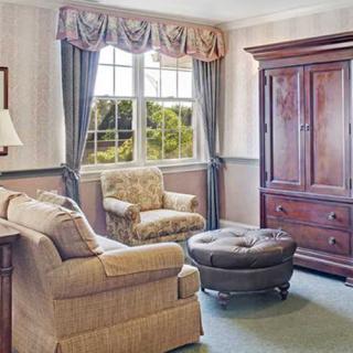 A cozy living room with a large window, comfortable armchairs, and elegant furnishings.