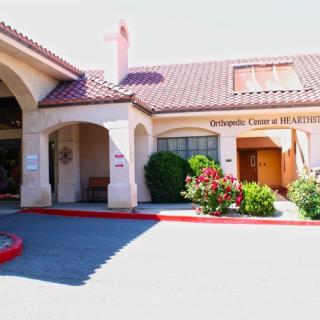 A sunny view of a building entrance with landscaping and architectural details.
