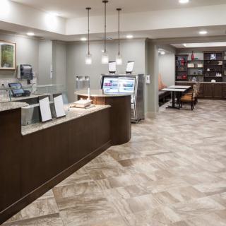 A modern hotel lobby with a reception desk and waiting area.