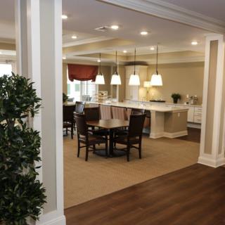 A modern open floor plan featuring a kitchen with an island and a dining area illuminated by pendant lighting.