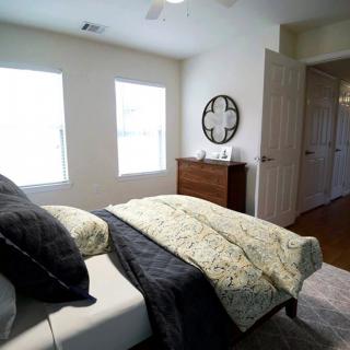 A cozy bedroom with a neatly made bed and elegant decor.