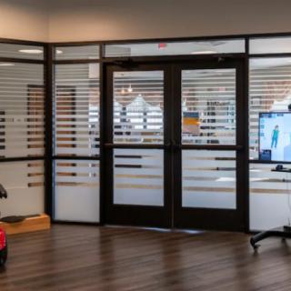 A modern office entrance with glass doors and sleek interior design.