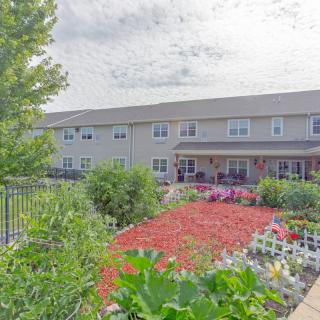 A two-story building with a beautifully landscaped garden in the foreground.