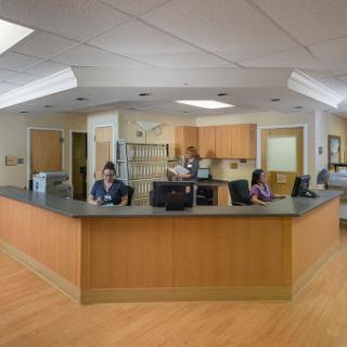A busy hospital reception area with staff attending to tasks.