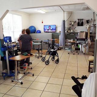 A physical therapy room equipped with various exercise tools and a television, where patients participate in rehabilitation activities.