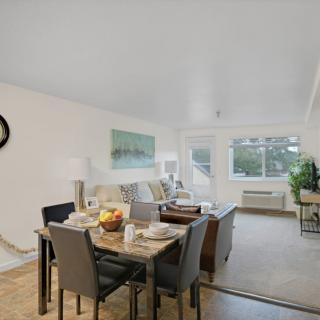 A modern living and dining area with minimalist decor and ample natural light.