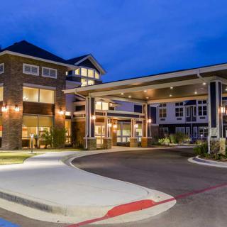 A well-lit building entrance with a covered driveway at night.