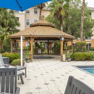 A cozy gazebo near a poolside in a tropical outdoor setting.