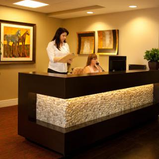 A modern office reception area with staff assisting visitors.