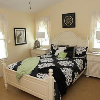 A well-decorated bedroom with a black and white bedspread and matching furniture.