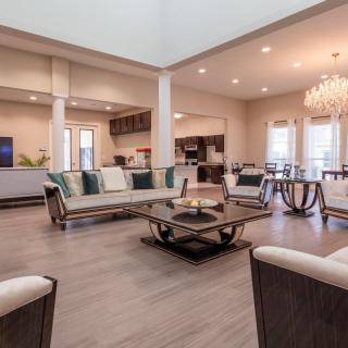 A spacious and modern living room with elegant furniture, open layout, and a stylish chandelier.